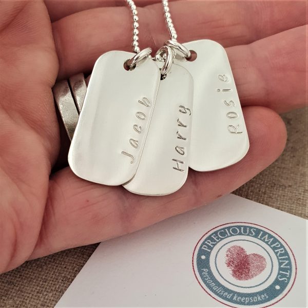 perspective photo of personalised small dog tag pendants